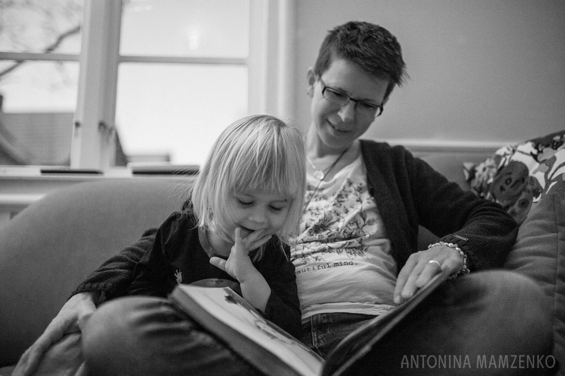 boy with enjoying book time with mum on the sofa