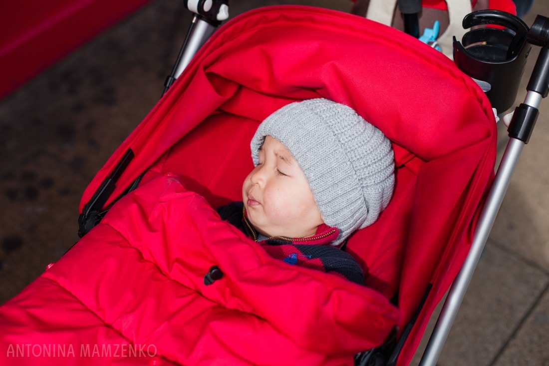 baby sleeping in a red pram