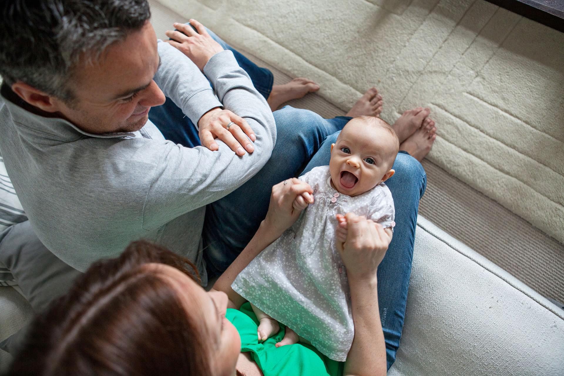 baby girl playing with her parents laughing