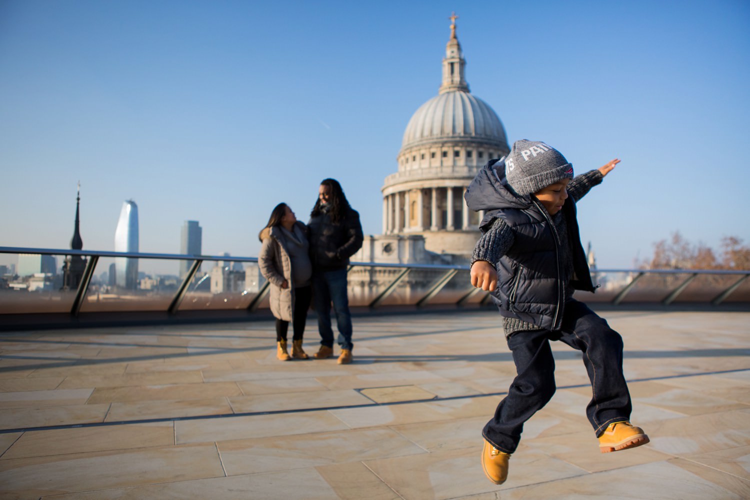 family photograph with boy jumping and St Paul's Cathedral in the background